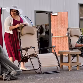 Beatrice, believing herself hidden beneath a blanket, scoffs as Hero and Antonia chide her while pretending she's not there in the play Much Ado About Nothing.